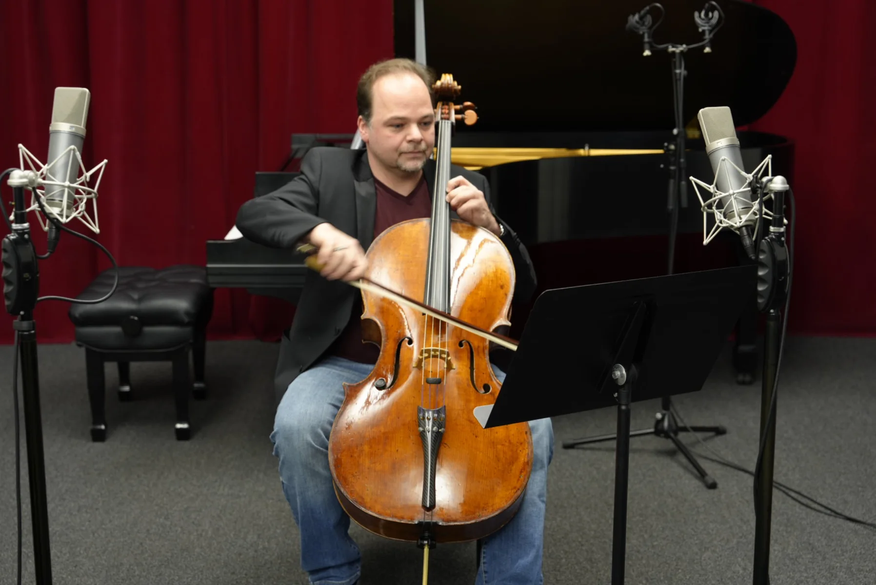 László Mező playing cello between two studio microphones